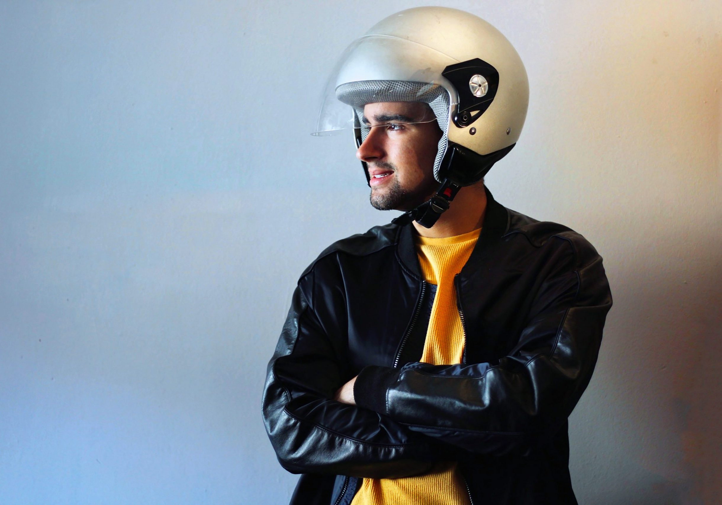 Young biker with a gray motorcycle helmet on. Road safety campaign. Copy Space.